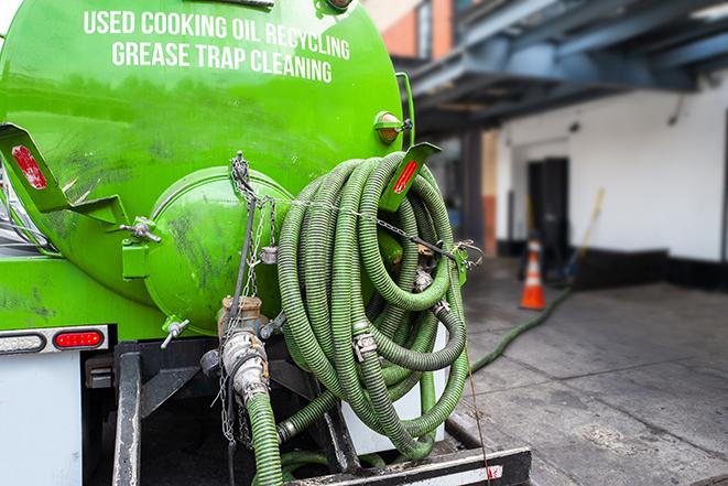 a technician pumping a grease trap in a commercial building in Lemoore CA